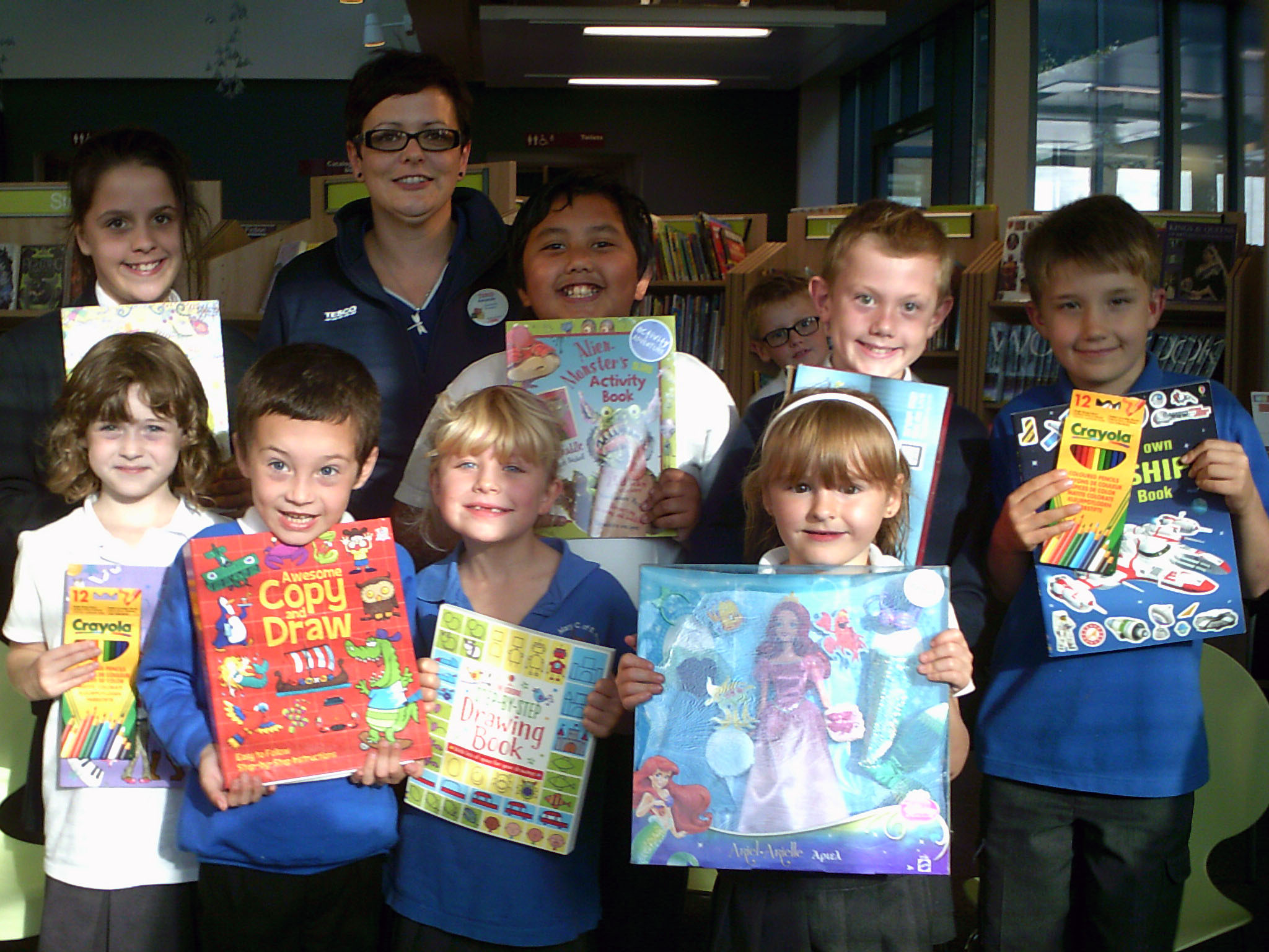 Some of the winners of the colouring competition: The back row from the left - Alexandra Archer (1st prize older category), Community Champion for Tesco Paignton Metro Amanda Nelhams, James Carlo Mund