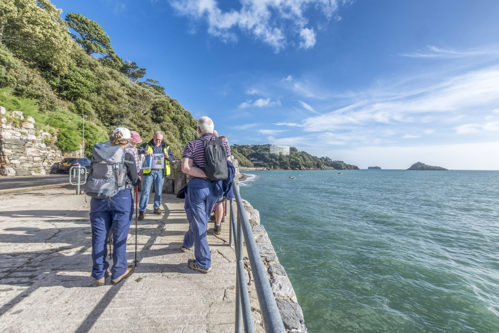 Group of people having a guided walk by the seafront.