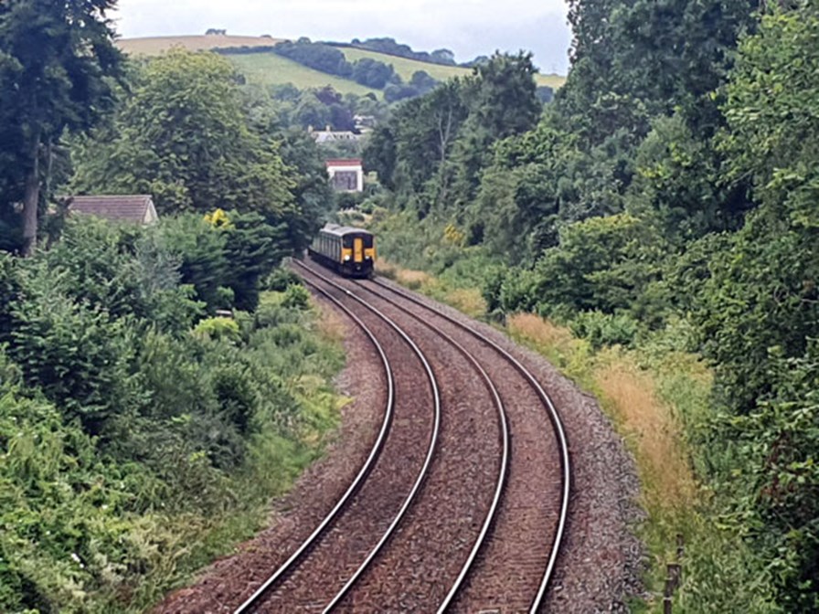 A train on the tracks approaching Torquay from Kingskerswell.