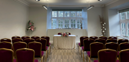 Rows of chairs and the alter in the Ceremony Room at Cockington Court, Torquay.