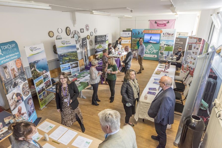 A tourism conference showing people visiting stands talking to the exhibitors.