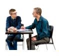 Two men sat at a table discussing some paperwork