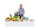 A man with a shopping basket in front of a table with fresh fruit and vegetables