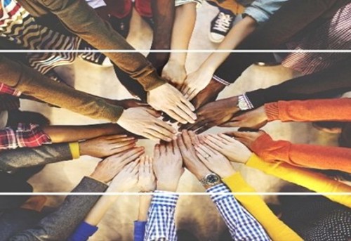 Multiple hands from diverse people joined in a circle, symbolizing unity and teamwork
