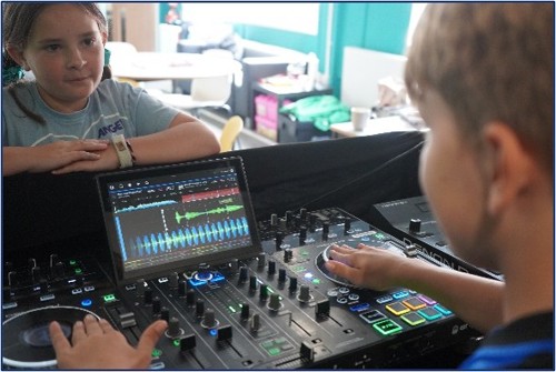 Children using a DJ mixing desk and audio software